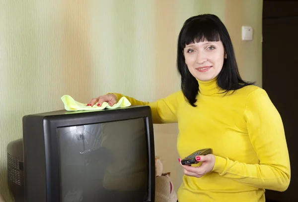 Женщина чистит телевизор — стоковое фото