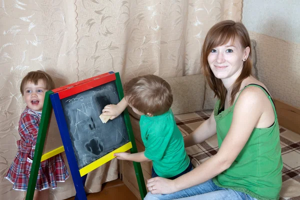 女人和儿童画在黑板上 — 图库照片