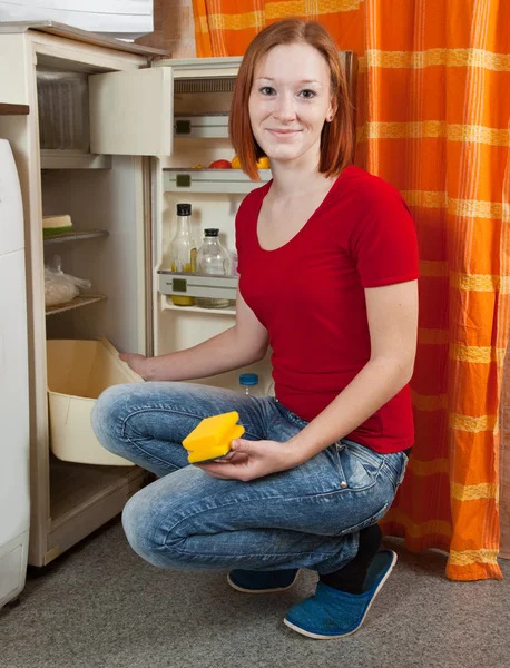 Frau taut Kühlschrank auf — Stockfoto
