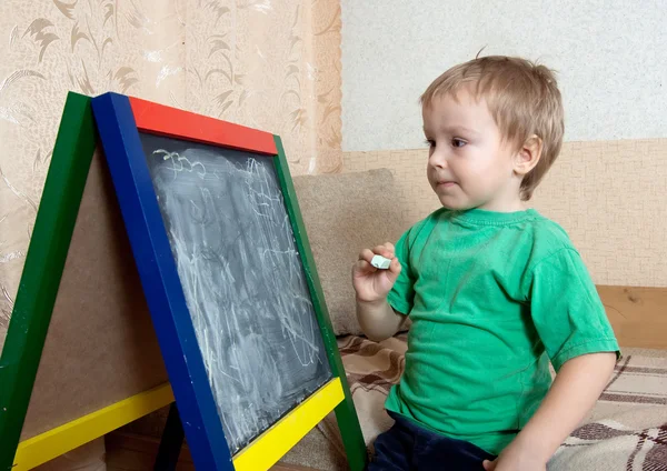 Enfant dessine sur tableau noir à la craie — Photo