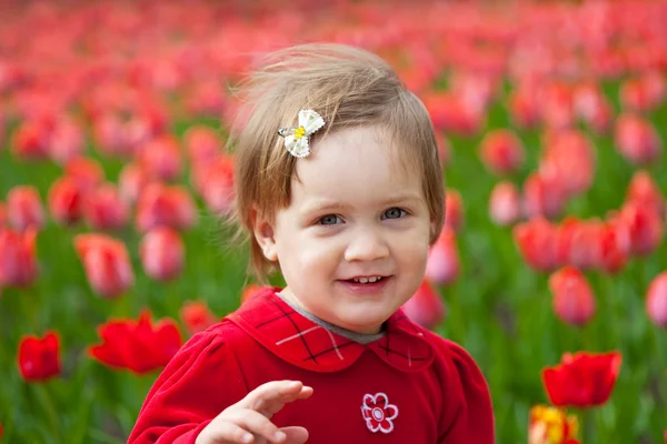Meisje in spring tulpen plant — Stockfoto