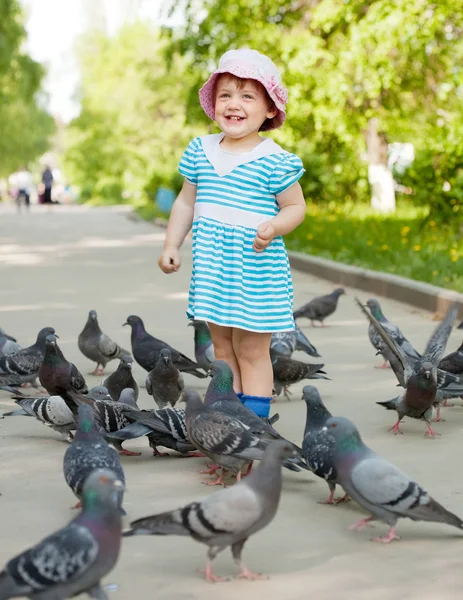 快乐的两年女孩喂鸽子 — 图库照片
