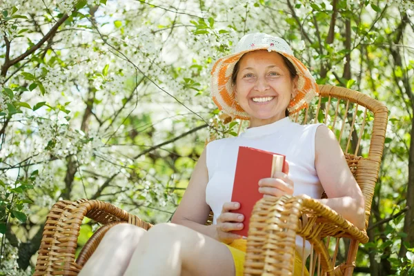 Happy mature woman against bloom garden — Stock Photo, Image