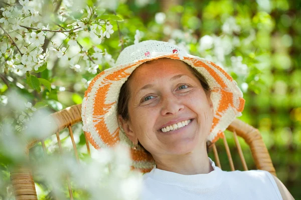 Mature woman in blossoming garden — Stock Photo, Image