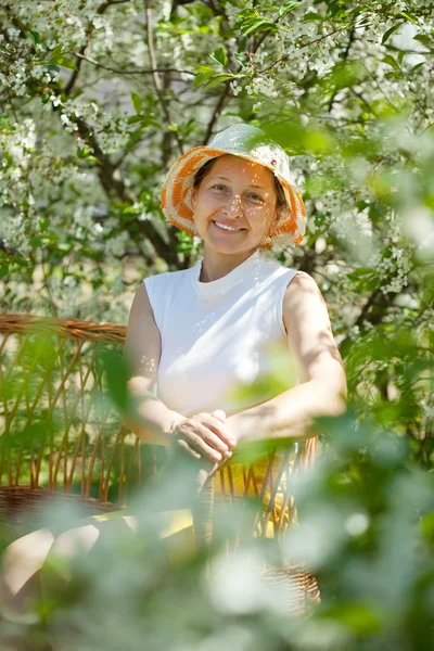 Volwassen vrouw in bloeiende tuin — Stockfoto