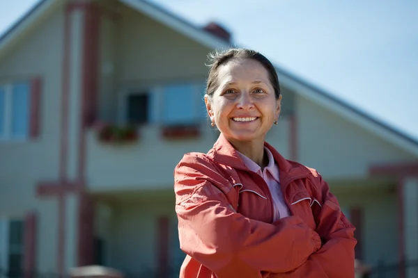 Mature woman against real estate — Stock Photo, Image
