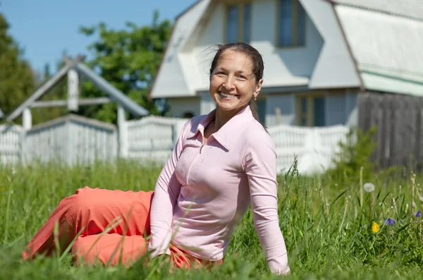 Happy mature woman against residence — Stock Photo, Image