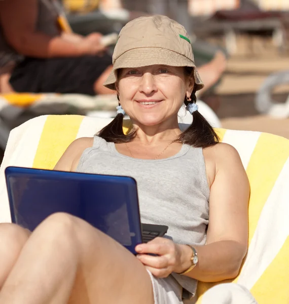 Mature woman with laptop at resort — Stock Photo, Image