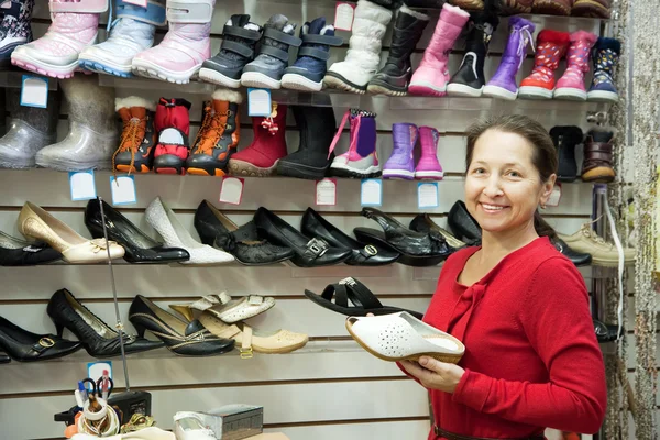 Volwassen vrouw kiest schoenen — Stockfoto