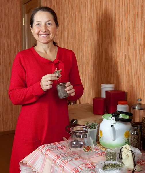 Mature woman brews herbs — Stock Photo, Image