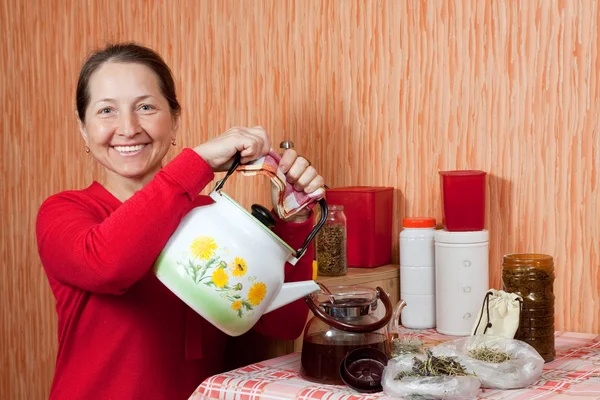 Mature woman brews herbs — Stock Photo, Image