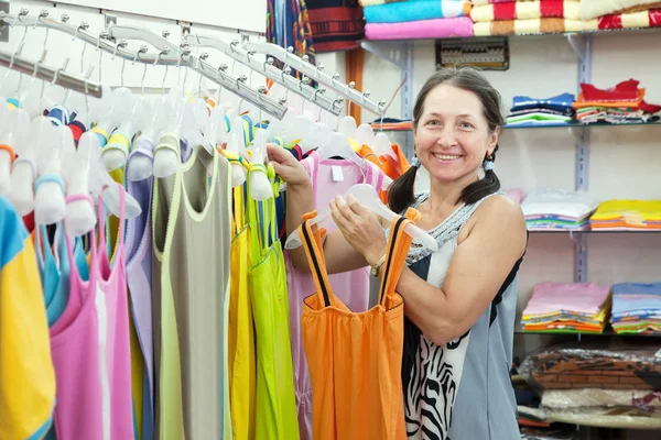 Donna matura sceglie il vestito al negozio — Foto Stock