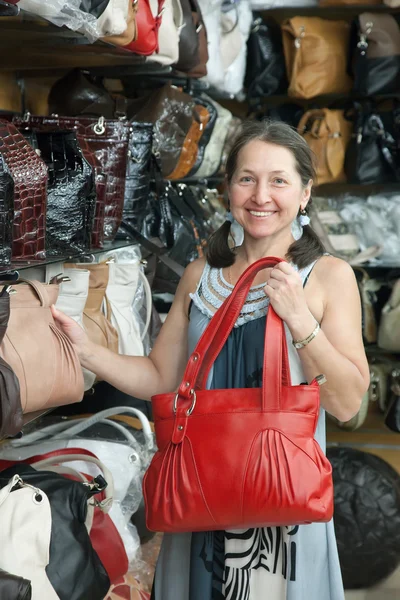 Зрелая женщина выбирает кожаную сумку — стоковое фото