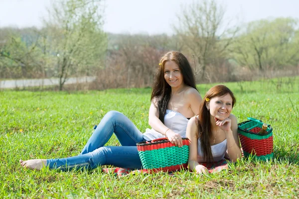Glada kvinnor kopplar av i gräset — Stockfoto