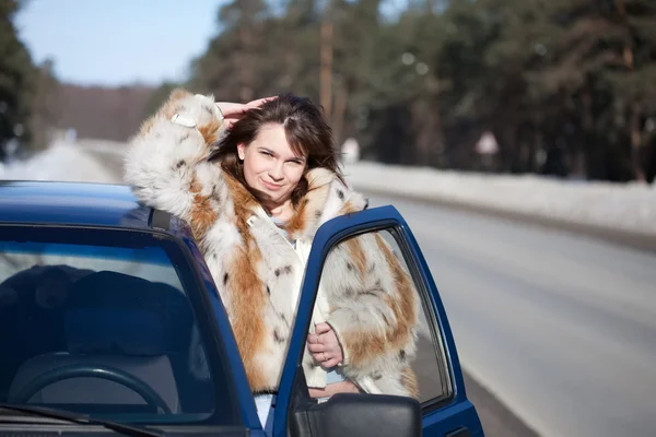 Жінка зі своєю машиною взимку — стокове фото