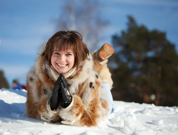 雪の上に横たわって、幸せな女の子 — ストック写真