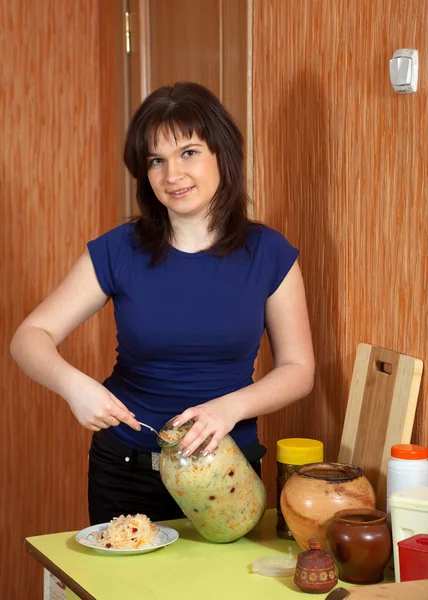 Женщина с банкой маринованной капусты — стоковое фото