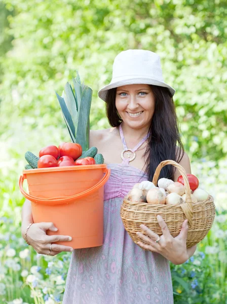 Happy woman holds vegetables harvest — Stock Photo, Image