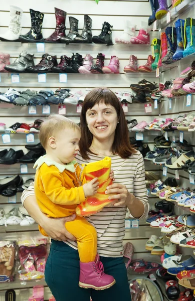 Happy mother with child chooses baby shoes — Stock Photo, Image