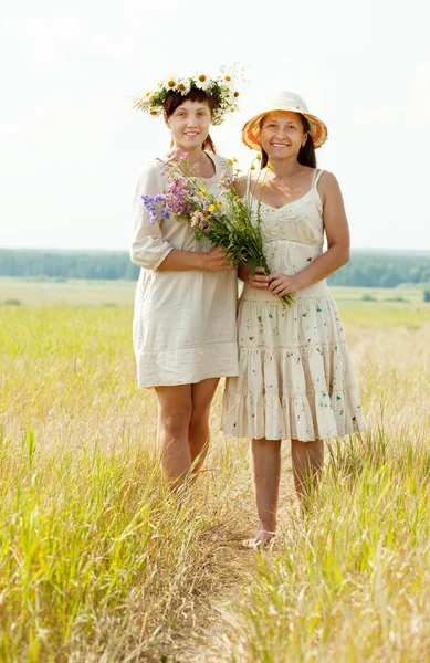 Happy women with flowers in summer — Stock Photo, Image