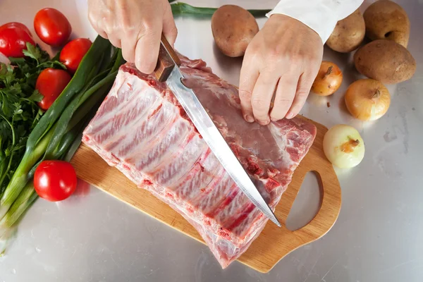 Vařit ruce řezání syrového masa — Stock fotografie