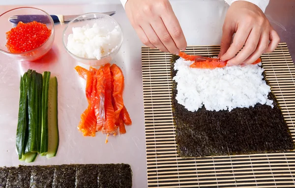 Μαγειρέψτε κάνοντας ρολά σούσι με σολωμό — Φωτογραφία Αρχείου