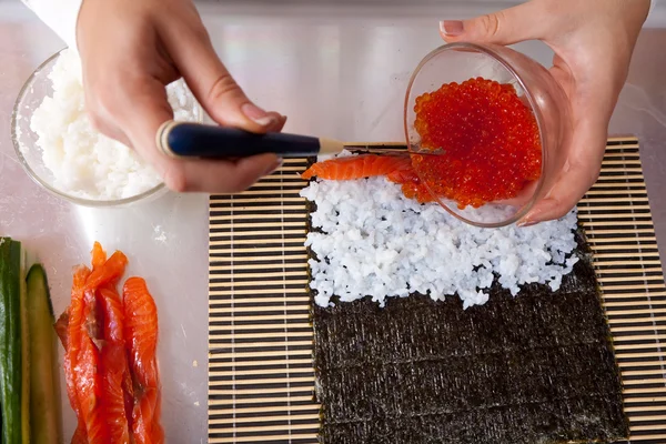 Nahaufnahme einer Köchin, die Sushi-Rollen herstellt — Stockfoto