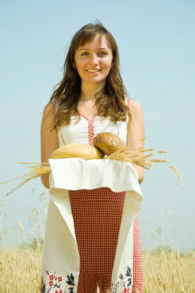 Meisje met brood op veld — Stockfoto
