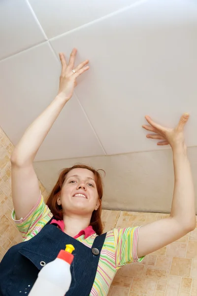 Woman glues ceiling tile — Stock Photo, Image