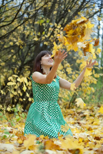 Chica lanzando hojas de arce en el aire —  Fotos de Stock
