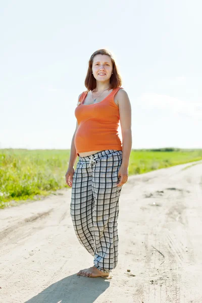 Беременная женщина в летнем поле — стоковое фото