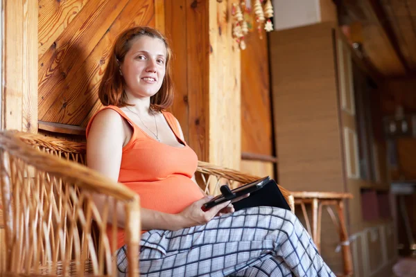 Zwangere vrouw leest e-boek — Stockfoto