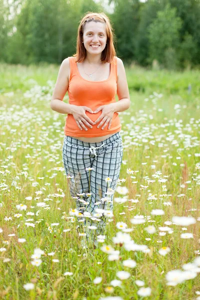 Беременная женщина с ромашкового завода — стоковое фото