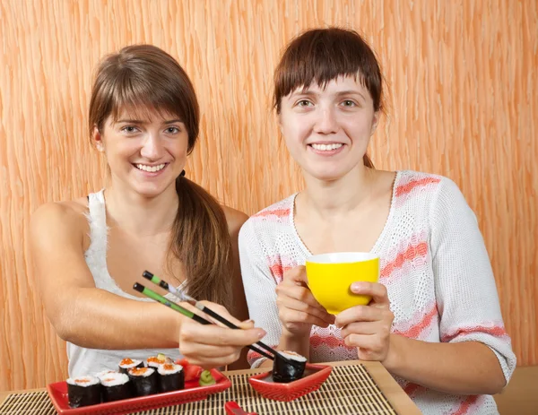Glückliche Frauen essen Sushi-Brötchen — Stockfoto