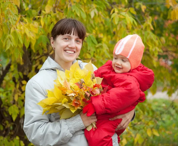 Happy mother with baby in autumn — Stok fotoğraf