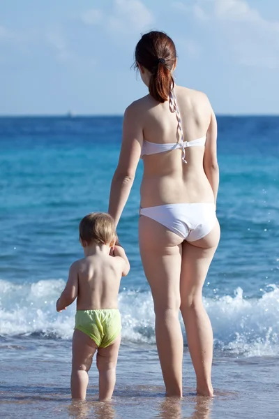 Dalgalar deniz içinde yürümeye başlayan çocuk ile anne — Stok fotoğraf