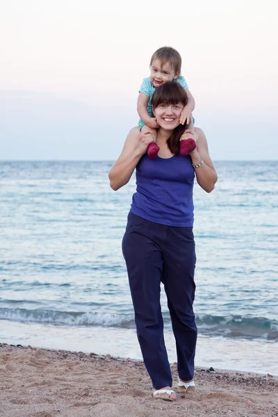 Mãe com a criança andando na praia — Fotografia de Stock