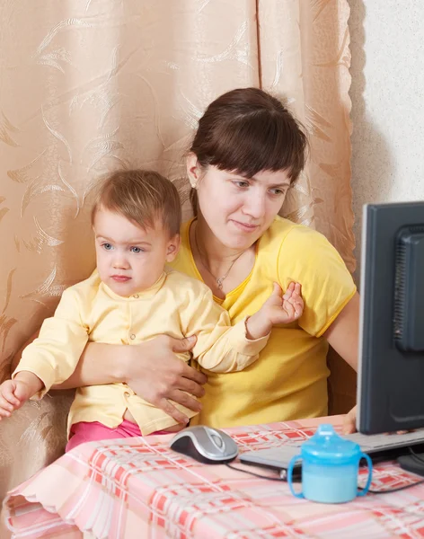 컴퓨터를 사용 하는 우는 아기를 가진 여자 — 스톡 사진