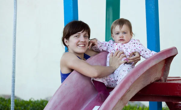 Счастливая мать с малышом на слайде — стоковое фото
