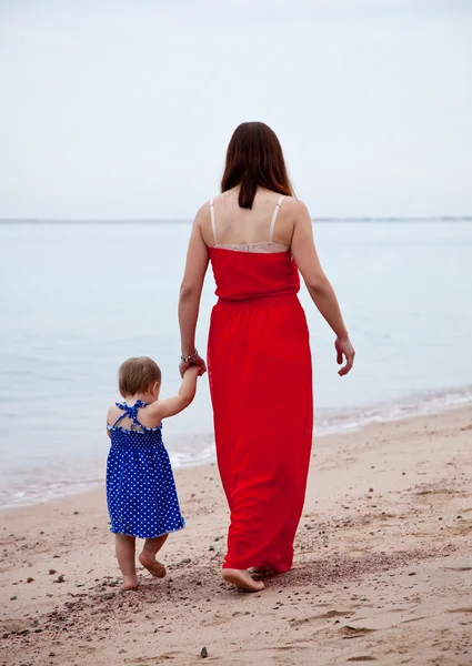 砂のビーチの上を歩いての幼児を持つ母 — ストック写真
