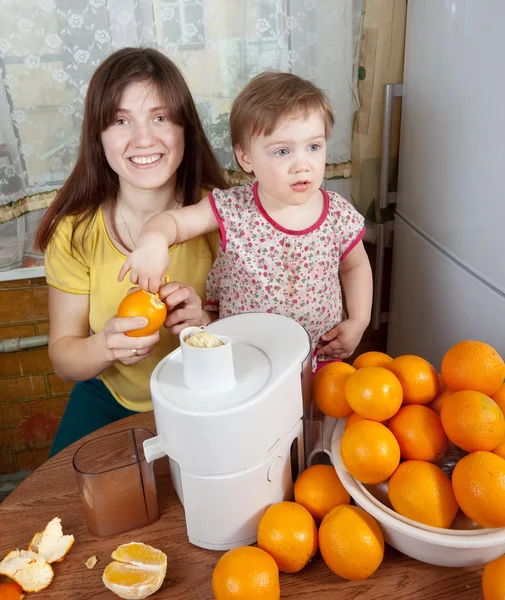 Мать и дочь делают апельсиновый сок — стоковое фото