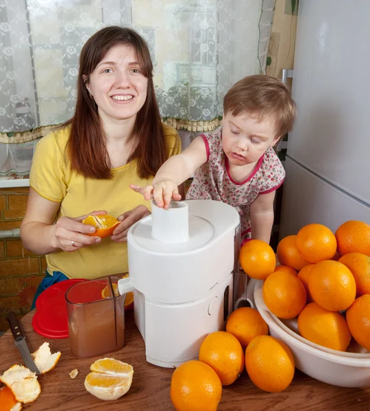 Mãe e filha fazendo suco de laranja — Fotografia de Stock