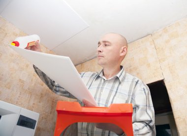 Guy glues ceiling tile clipart