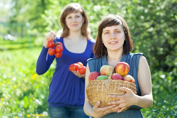 Girls with harvest in garden — Stock Photo, Image