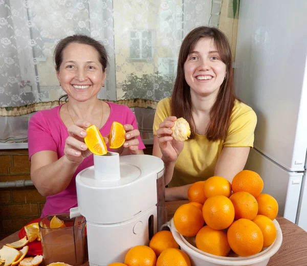 Mulheres fazendo suco de laranja fresco — Fotografia de Stock