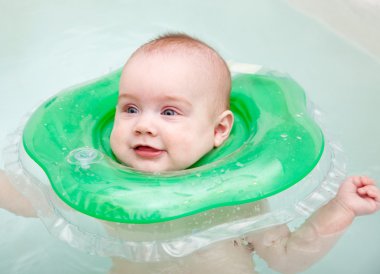 Baby swimming with neck swim ring clipart