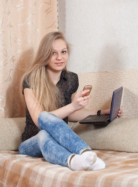 Girl speaks by mobile and uses laptop — Stock Photo, Image