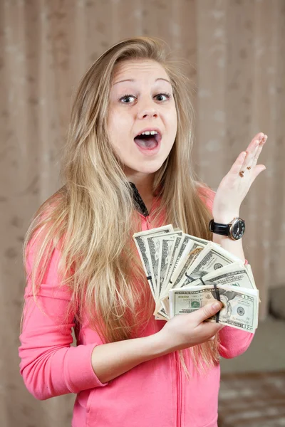 Mujer feliz muestra paquetes de dólares estadounidenses — Foto de Stock