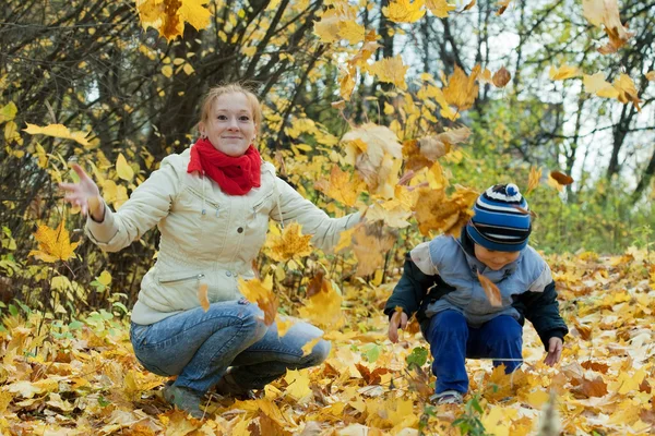 Μητέρα με αγόρι ρίχνει επάνω σε φύλλα σφενδάμου — Φωτογραφία Αρχείου