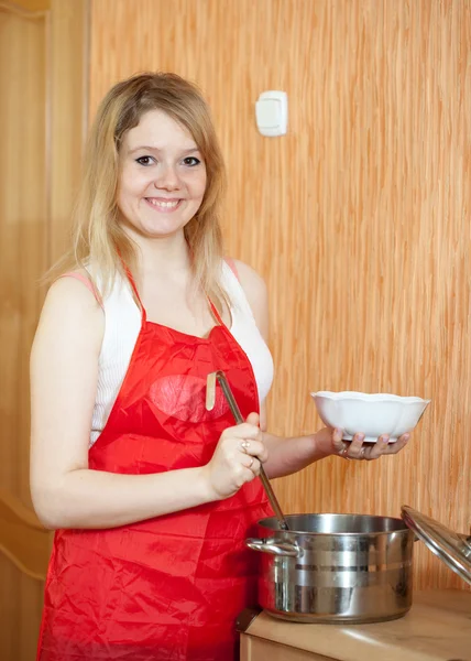 Frau gießt die Suppe ein — Stockfoto